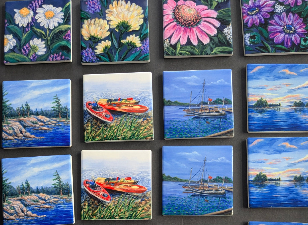 Collection of small tiles with various artistic designs including flowers and landscapes.