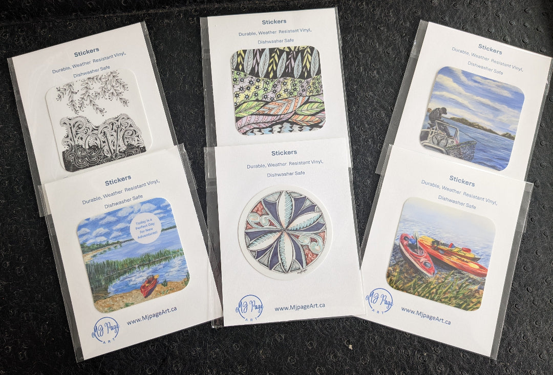 Set of nature-themed stickers in clear plastic sleeves on a dark surface