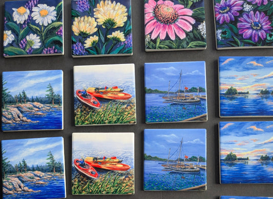 Collection of small tiles with various artistic designs including flowers and landscapes.