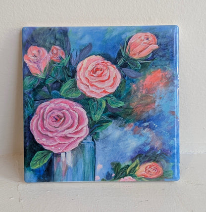 Painting of pink roses in a blue vase on a white background