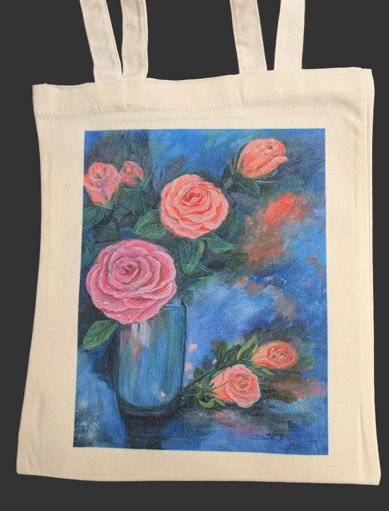 Tote bag with a painting of pink roses in a blue vase on a black background