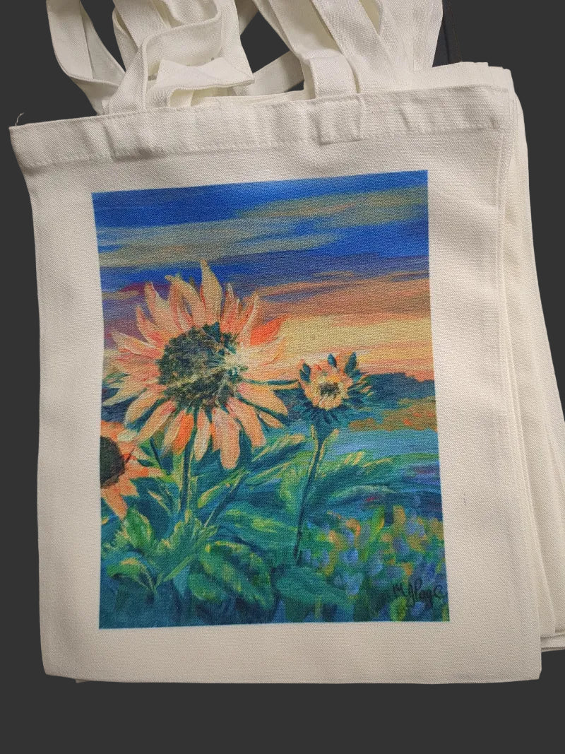 White tote bag with a colorful sunflower design on a black background